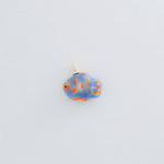 Fish-shaped charm with blue and orange design on a light gray background
