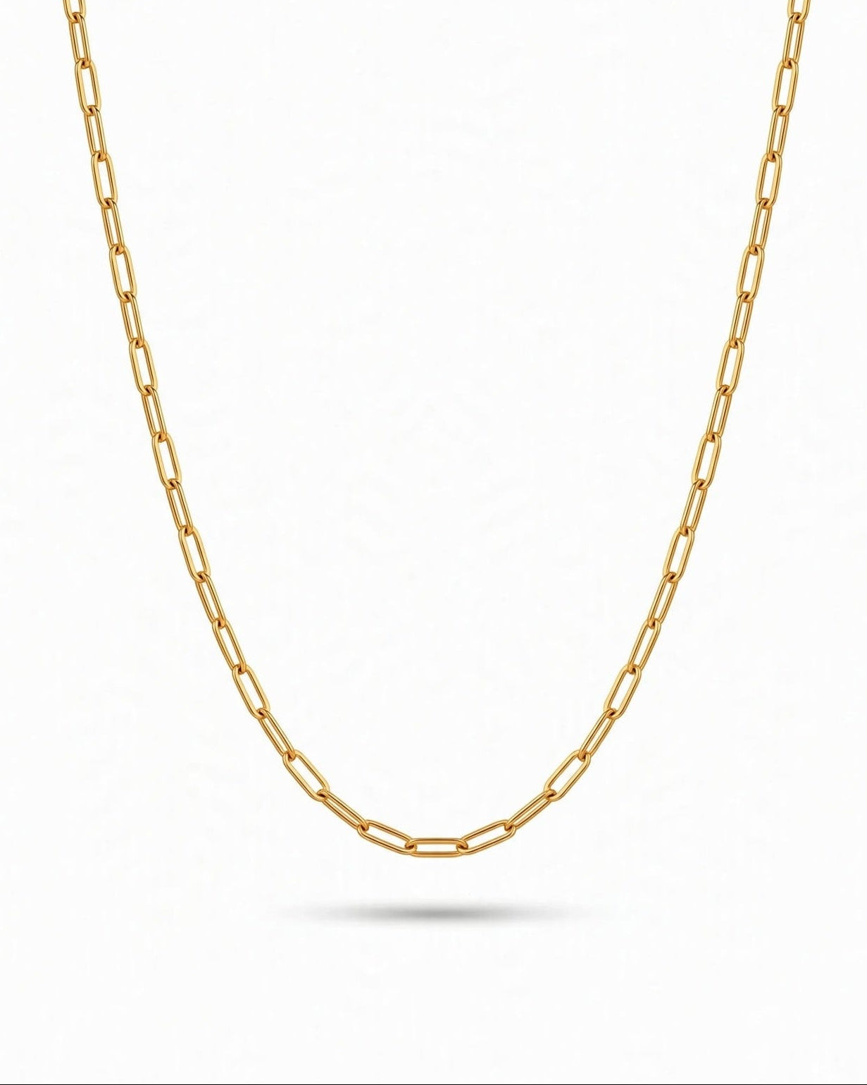 A gold paperclip chain necklace displayed in a U-shape against a clean white background with a soft shadow underneath.