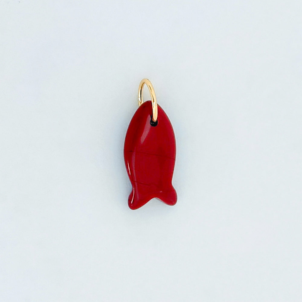 Red carnelian fish-shaped charm on a light gray background