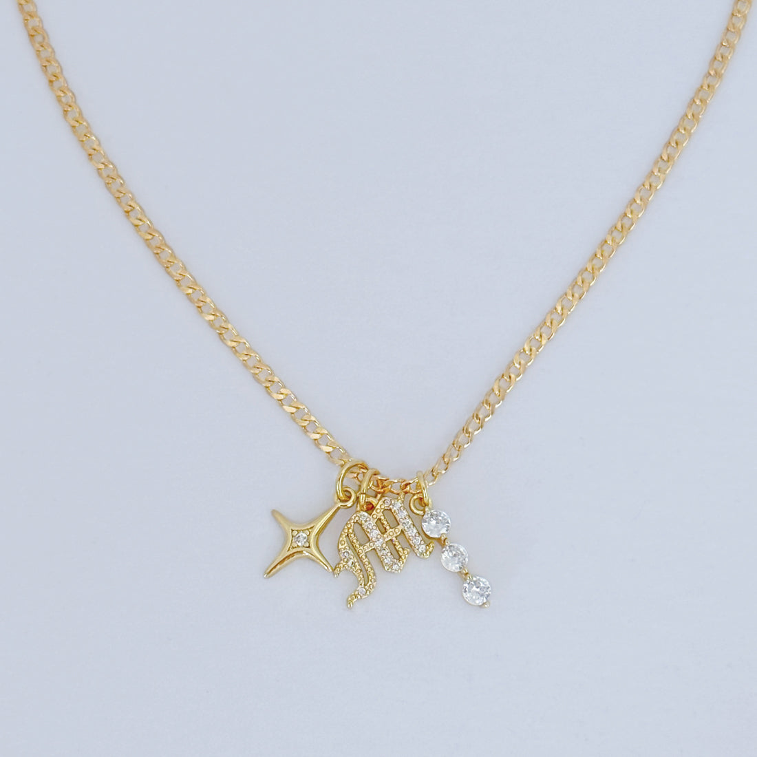Gold-filled curb chain with three charm pendant: initial, star, and CZ dangle