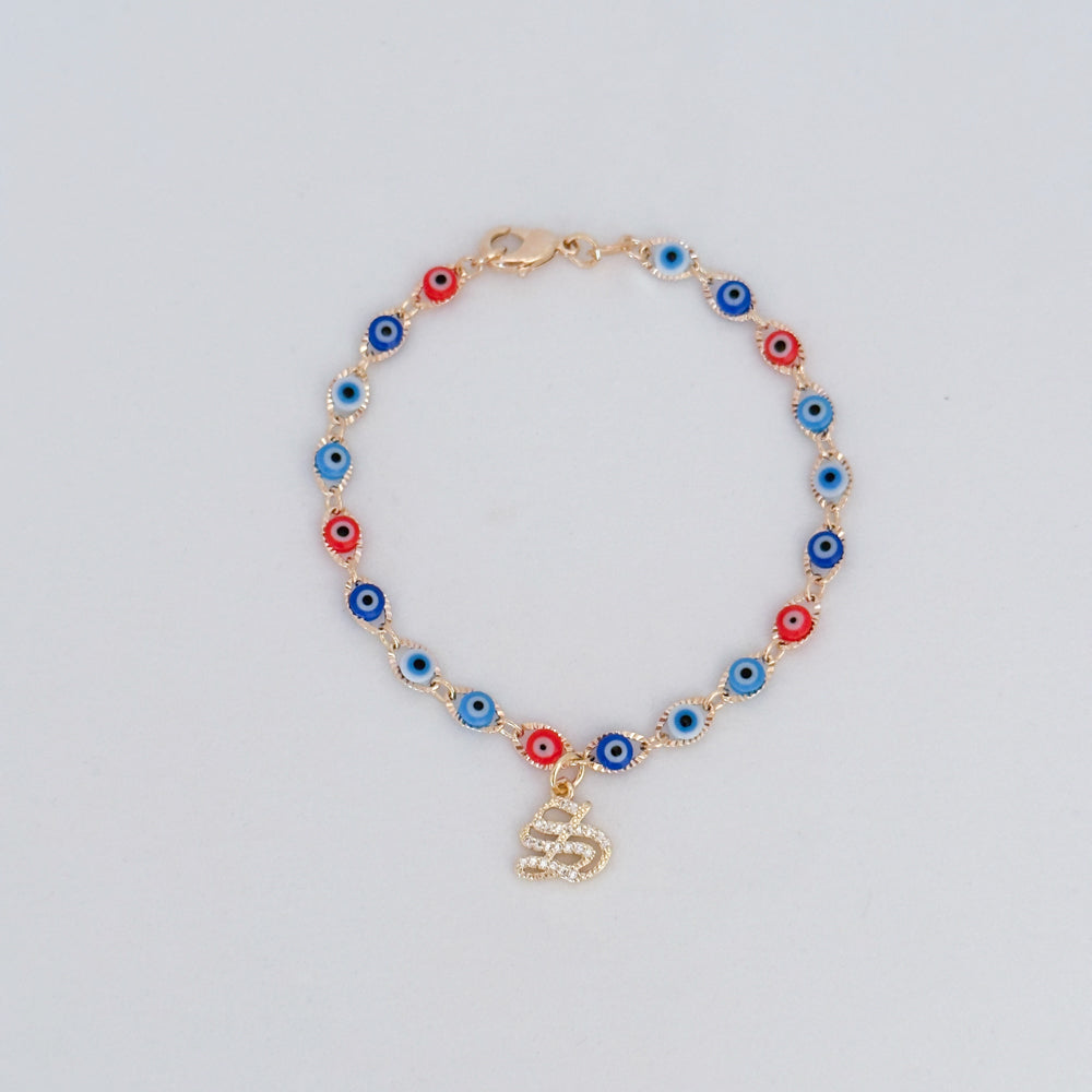 Bracelet with colorful evil eye beads and gold initial charm on light background