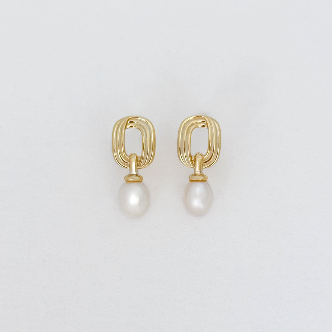 Gold-plated sterling silver rectangle vintage style pearl drop earrings with white pearls, shown on a light gray background.