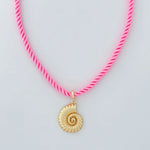 Necklace with a pink cord and gold shell pendant on a light gray background