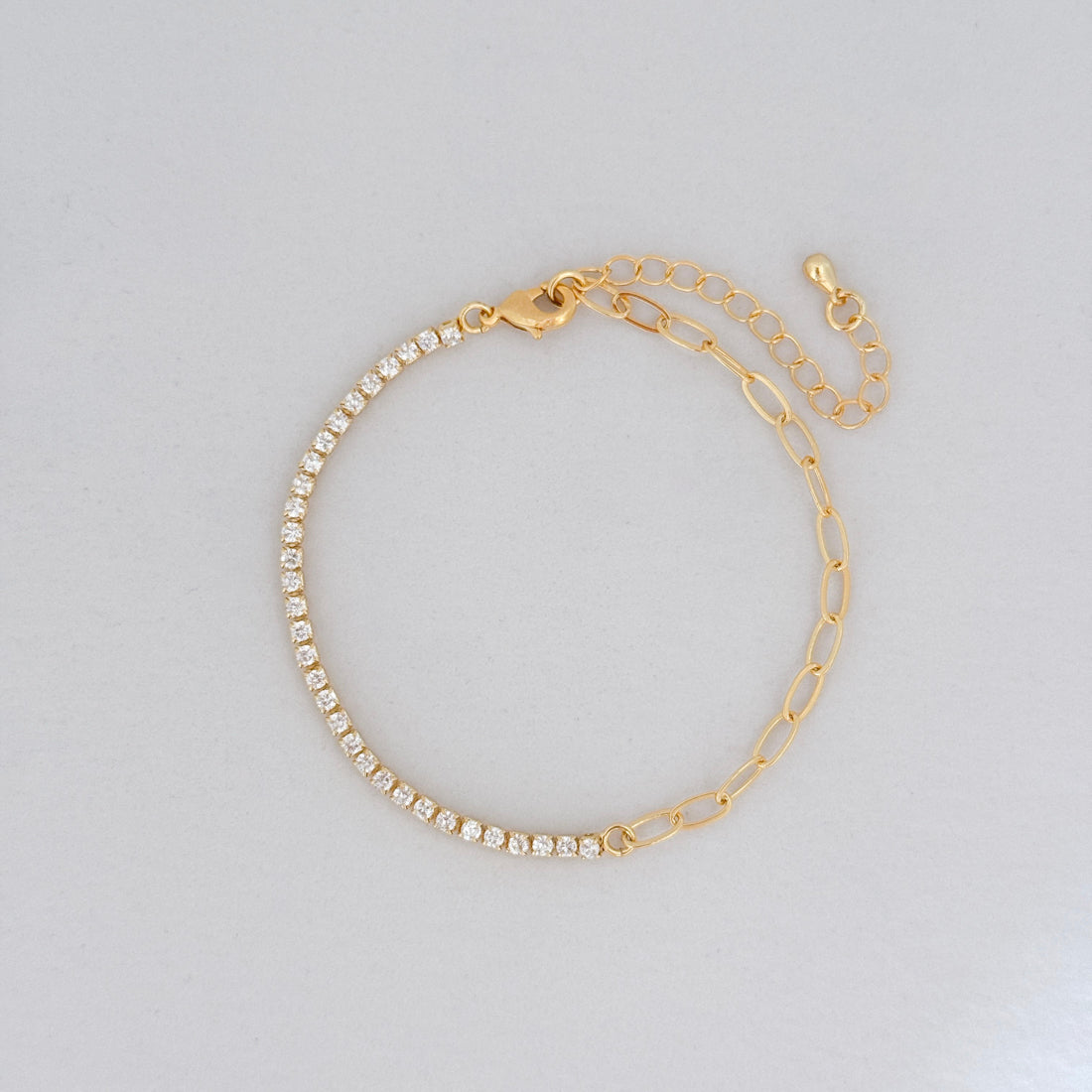 14k gold-filled CZ tennis bracelet paired with paperclip chain and extender, shown on flat surface